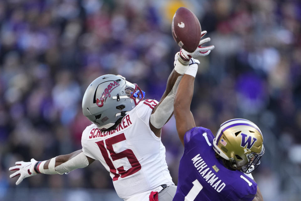 Washington State running back Djouvensky Schlenbaker (15) can't bring in a pass against Washington cornerback Jabbar Muhammad (1) during the first half of an NCAA college football game Saturday, Nov. 25, 2023, in Seattle. (AP Photo/Lindsey Wasson)