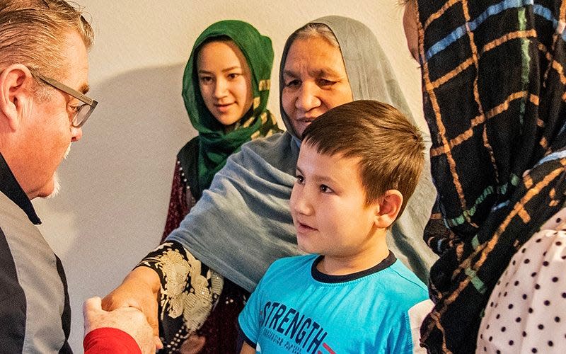 Mike Sullivan of the Welcome to America Project talks with a family of Iraqi refugees who were recently resettled in Arizona.