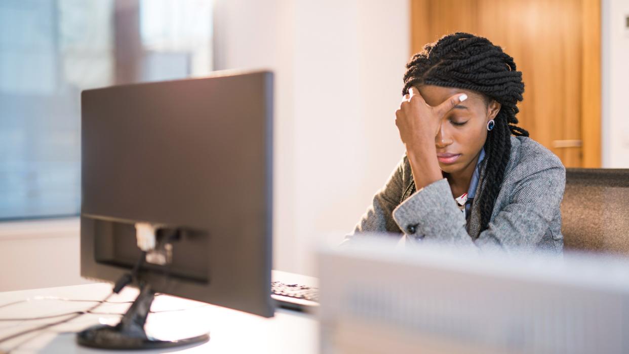 Depressed African woman at work.