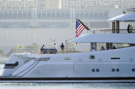 People look on from the super yacht Amadea as it arrives to the San Diego Bay Monday, June 27, 2022, seen from Coronado, Calif. The $325 million superyacht seized by the United States from a sanctioned Russian oligarch arrived in San Diego Bay on Monday. (AP Photo/Gregory Bull)