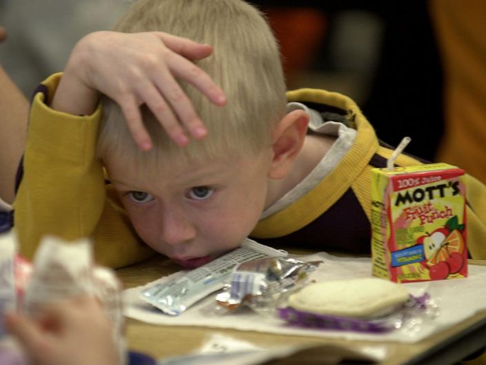 A boy eats school lunch in 2001