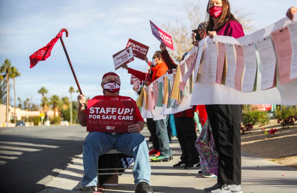 Peter Reinzuch, the husband of a nurse, sits in solidarity with nurses protesting staffing shortages as well as other patient care concerns outside of Desert Regional Medical Center, Thursday, Jan. 13, 2022, in Palm Springs, Calif. 