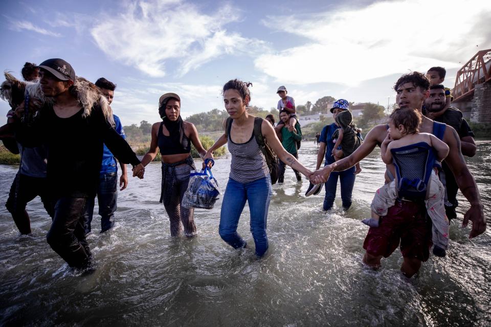 Migrants hold hands for safety as they cross the Rio Grande River into the U.S. in Eagle Pass, Texas on July 20, 2023, from Piedras Negras, Coahuila, Mexico. The migrants were part of a group of nearly 30 migrants who crossed hoping to seek asylum in the U.S.