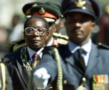 <p>Mugabe inspects troops at the opening of Parliament in 2000. The fifth Parliament since independence in 1980 saw the largest opposition to Mugabe’s ZANU-PF party, with the Movement for Democratic Change holding 57 seats in the 150-seat chamber. (Photo: Howard Burditt/Reuters) </p>