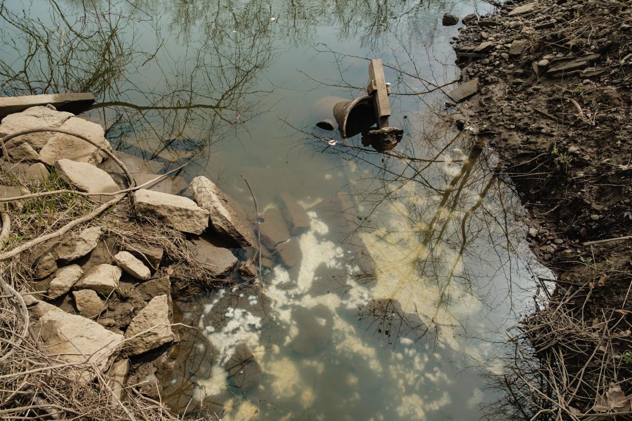 A chemical substance that had apparently been dumped on Monday at Hawkins Water Treatment, 1161 Commercial Ave. SE in New Philadelphia, subsequently flowed through a storm drain into the Tuscarawas River. The substance can be seen submerged in the water, and on the soil nearby.