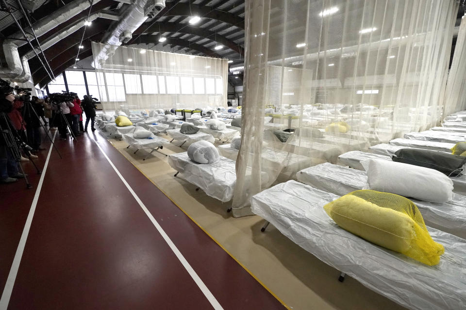 Members of the media examine a portion of the Cass Recreational Complex, in Boston, Wednesday, Jan. 31, 2024, that has been turned into a temporary shelter site for families experiencing homelessness. The facility was opened to legislators, community leaders, and members of the media Wednesday ahead of its planned opening as the state continues to grapple with an influx of homeless migrants. (AP Photo/Steven Senne)