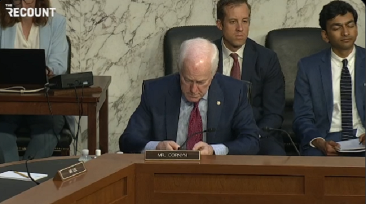 Sen John Cornyn is spotted on his phone during a hearing of the Senate Judiciary Committee on domestic terrorism in response to the Buffalo shooting (Twitter - The Recount)