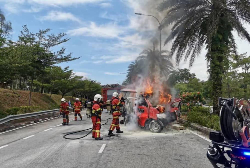 Firemen douse flames from the burning courier lorry where the driver was trapped after a crash along Jalan Tasek Utara in Johor Baru, September 28, 2021. — Picture courtesy of the Johor Fire and Rescue Department