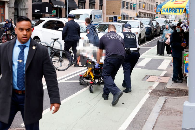 Paramedics attend to a person who lit themselves on fire near Manhattan Criminal Court on April 19, 2024 in New York City