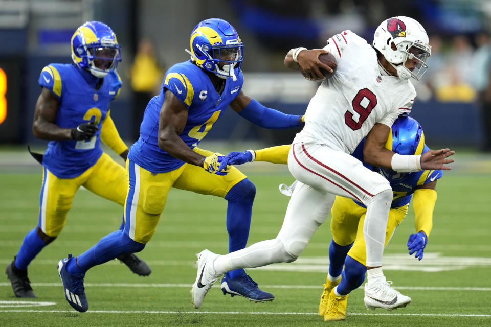 Arizona Cardinals quarterback Joshua Dobbs (9) is tackled by Los Angeles Rams safety Quentin Lake (37), bottom right, during the second half of an NFL football game Sunday, Oct. 15, 2023, in Inglewood, Calif. (AP Photo/Ashley Landis)