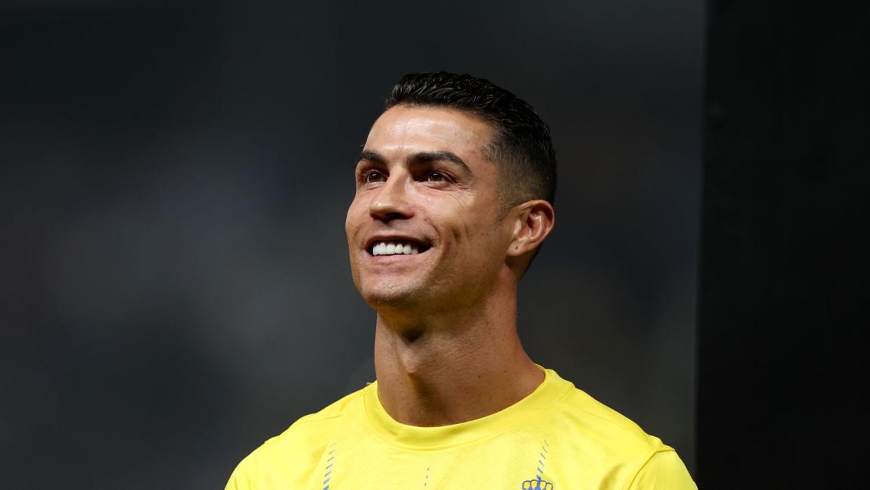 al nassr soccer player cristiano ronaldo looking up and smiling before a match