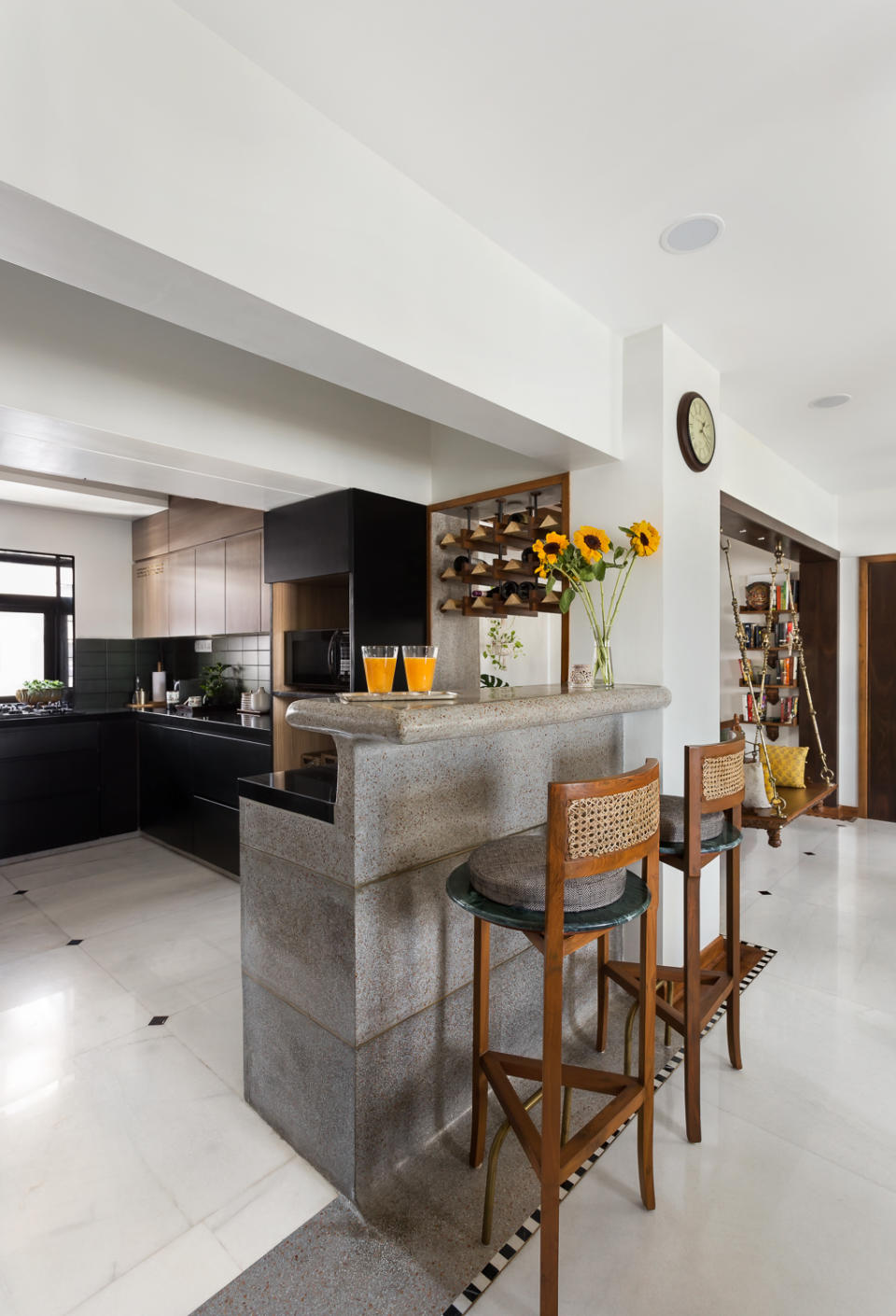 With minimal design, it's all about the details. Leftover marble chips were uniformly cut to create the black-and-white, striped skirting that visually connects all social spaces. Similarly, note how terrazzo flows from the breakfast counter downwards, drawing the eye into the passage towards the bedrooms.