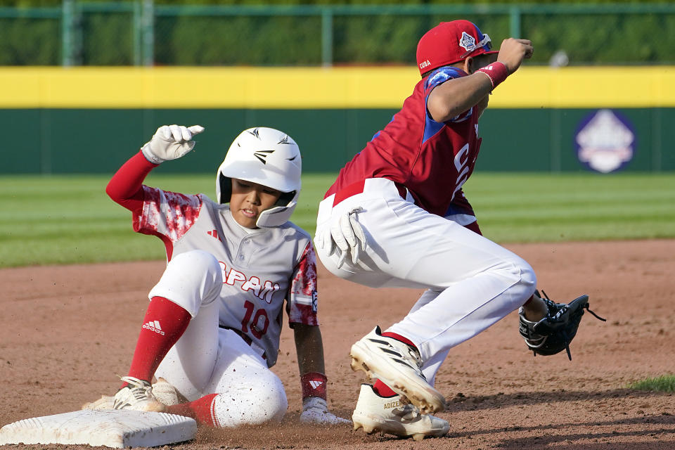 Japan's Shuma Tachibana (10) advances to third on a passed ball, next to Cuba's Liusban Sanchez during the fourth inning of a baseball game at the Little League World Series tournament in South Williamsport, Pa., Wednesday, Aug. 16, 2023. (AP Photo/Tom E. Puskar)