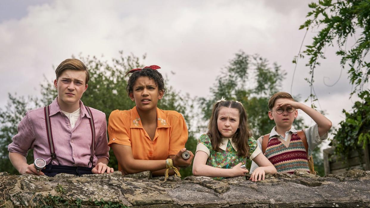  Julian (Elliott Rose), George (Diaana Babnicova), Anne (Flora Jacoby Richardson), and Dick (Kit Rakusen) leaning on a wall. 