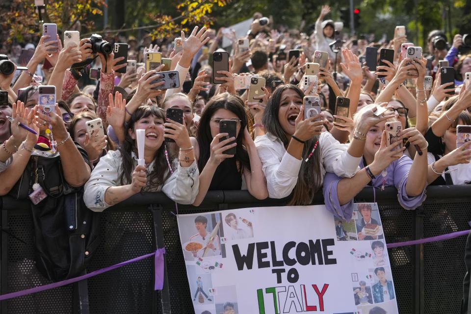 Fans react as musician Jin departs the Gucci Spring Summer 2025 collection, that was presented in Milan, Italy, Friday, Sept. 20, 2024. (AP Photo/Luca Bruno).