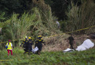 <p>Firefighters carry a body bag that contains human remains recovered at the site where a Boeing 737 plummeted into a yuca field with more than 100 passengers on board, in Havana, Cuba, Friday, May 18, 2018. (Photo: Desmond Boylan/AP) </p>