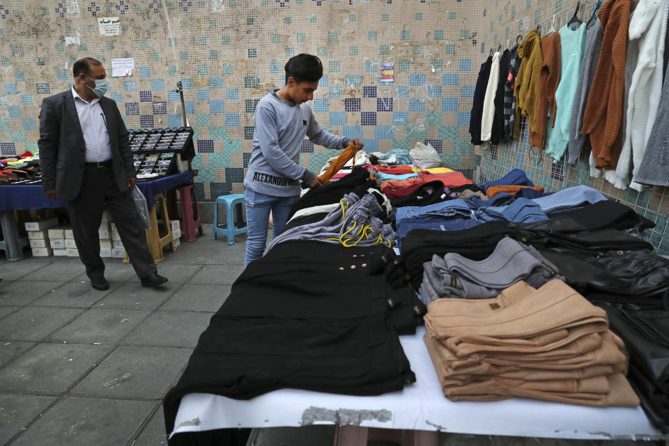 A street vendor adjusts clothes at his stall at the gate of a subway station in downtown Tehran, Iran, Monday, Nov. 1, 2021. As U.S. sanctions and the coronavirus pandemic wreak havoc on Iran's economy, suicides in the country increased by over 4%, according to a government study cited by the reformist daily Etemad. About 1 million Iranians have lost their jobs, and unemployment has climbed over 10% — a rate that is nearly twice as big among youths. (AP Photo/Vahid Salemi)