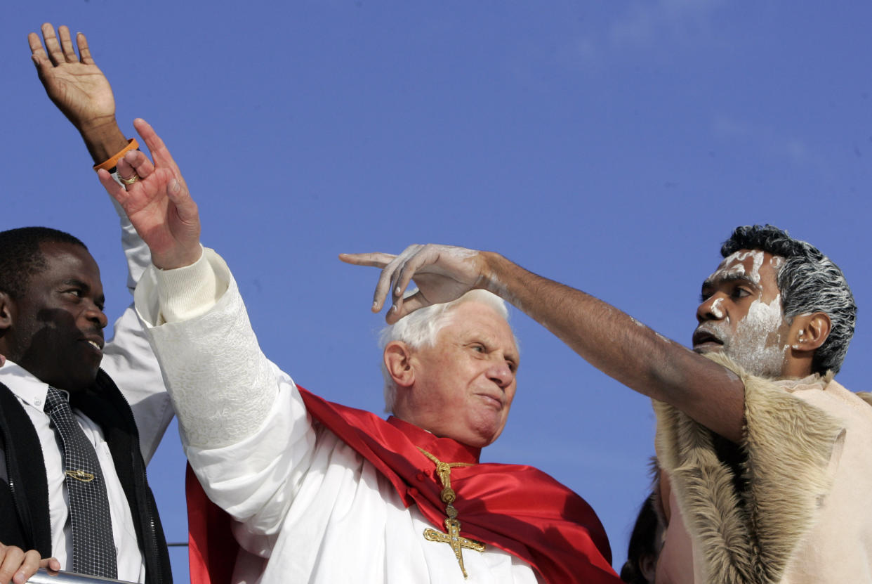 FILE - Pope Benedict XVI, center, talks to an Australian Aborigine while waving to pilgrims aboard a harbor cruise in Sydney, Australia, on July 17, 2008. Pope Emeritus Benedict XVI, the German theologian who will be remembered as the first pope in 600 years to resign, has died, the Vatican announced Saturday. He was 95. (AP Photo/Gregorio Borgia, File)