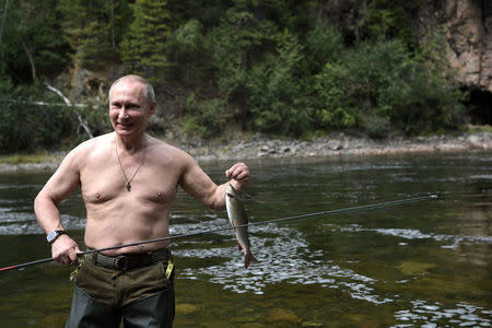 Russian President Vladimir Putin holds a fish he caught during the hunting and fishing trip which took place on August 1-3 in the republic of Tyva in southern Siberia, Russia, in this photo released by the Kremlin on August 5, 2017. Sputnik/Alexei Nikolsky/Kremlin via REUTERS