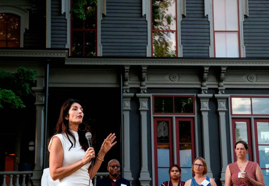 Guests listen as Tina Konidaris speaks during a fundraising event for CASA, an affordable housing nonprofit, outside the Andrews-Duncan House on Tuesday, May 16, 2023, in Raleigh, N.C. Konidaris and her partner, Jeff Turpin, moved into the historic house in February after working to renovate it for about five years.