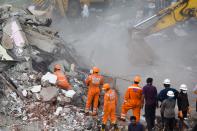 Rescue workers search for survivors in the rubble of a collapsed five-storey apartment building in Mahad. (Photo by PUNIT PARANJPE/AFP via Getty Images)