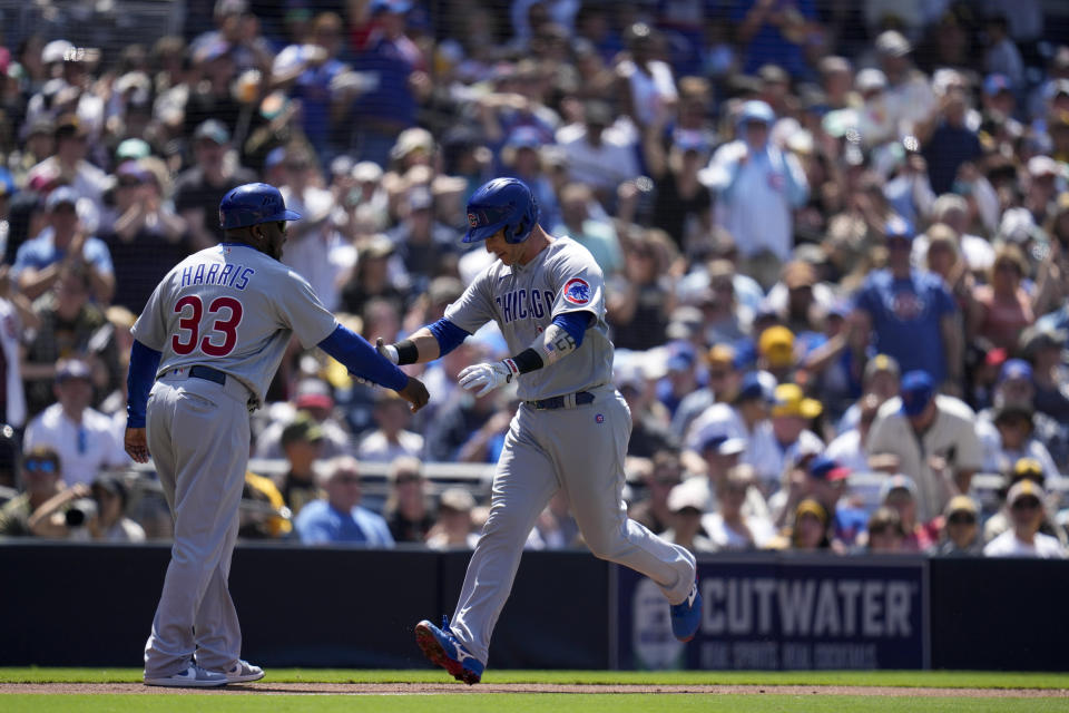 Chicago Cubs' Yan Gomes, right, is greeted by third base coach Willie Harris (33) after hitting a home run during the second inning of a baseball game against the San Diego Padres, Sunday, June 4, 2023, in San Diego. (AP Photo/Gregory Bull)