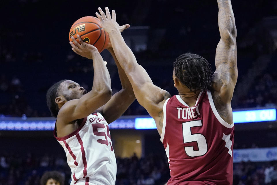 Oklahoma guard Elijah Harkless (55) shoots as Arkansas guard Au'Diese Toney (5) defends in the first half of an NCAA college basketball game Saturday, Dec. 11, 2021, in Tulsa, Okla. (AP Photo/Sue Ogrocki)