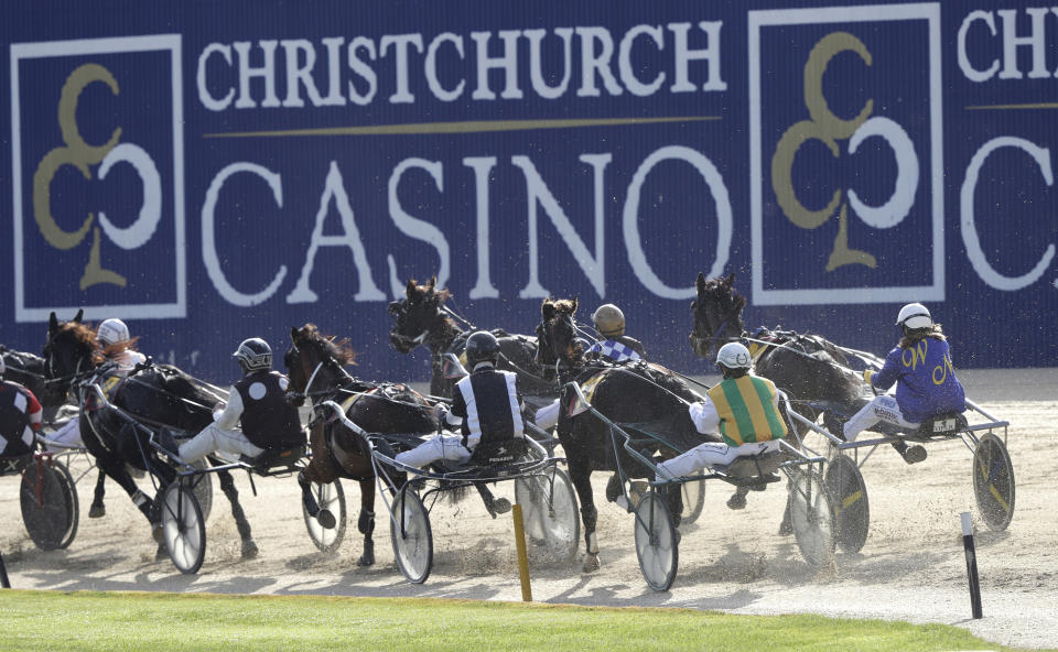 The field in race one take the first bend at the Addington Raceway in Christchurch, New Zealand, Thursday, May 28, 2020 in Christchurch, New Zealand, Thursday, May 28, 2020. New Zealand's financially troubled horse racing industry has reopened Thursday after being shuttered for weeks because of the coronavirus outbreak, leading the return of organized sports as the nation moves toward normality. A harness racing meeting which took place without fans at the Addington racecourse in Christchurch was the first since New Zealand went into strict lockdown on March 24. (AP Photo/Mark Baker)