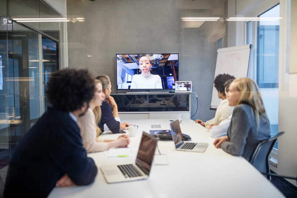 Group of business people having video conference in boardroom. Diverse business professionals having video conference meeting in office.