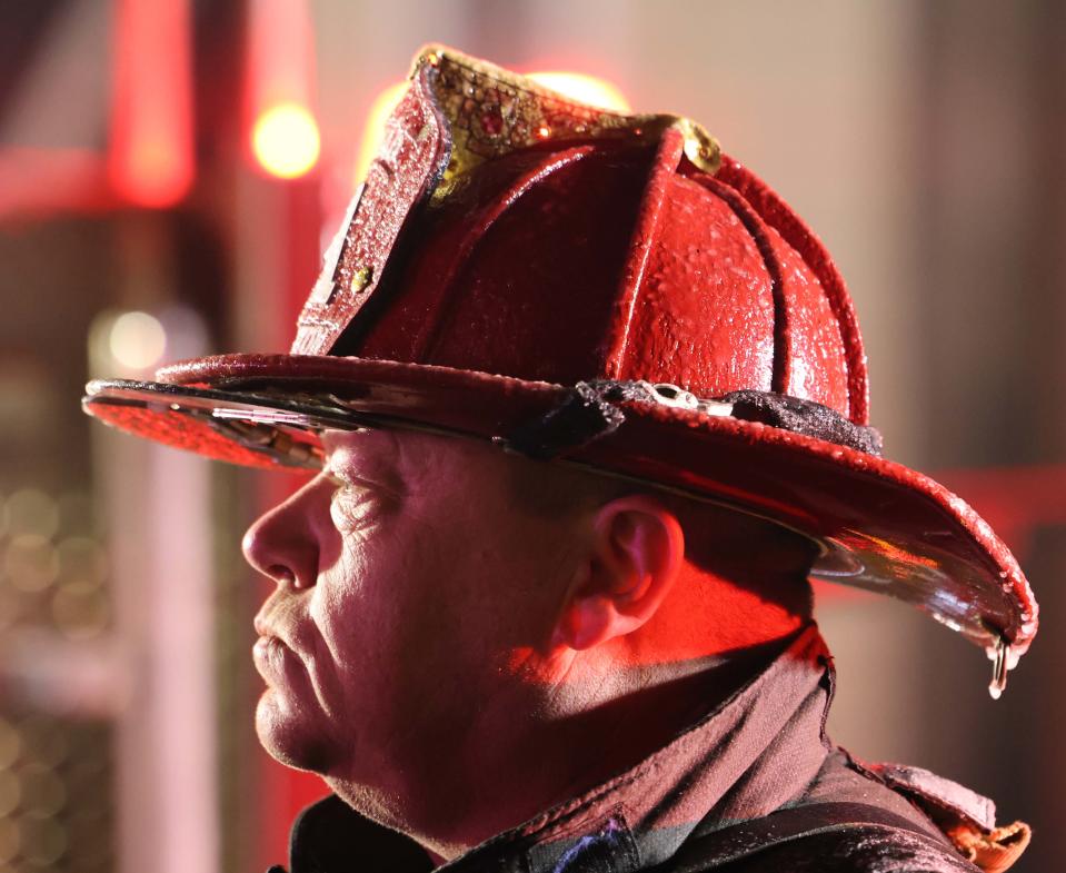 A firefighter's helmet has crystalized ice on it as Brockton firefighters battle a three-alarm house fire at 41 Glenwood St. on Saturday, Jan. 15, 2022.