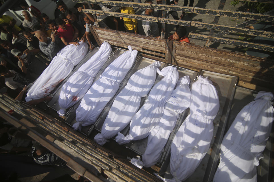 Bodies of the Abu Rayash family killed in Israeli shelling are loaded on the truck at Edwin Hospital in Rafah, Gaza Strip, Thursday, Oct. 12, 2023. (AP Photo/Hatem Ali)