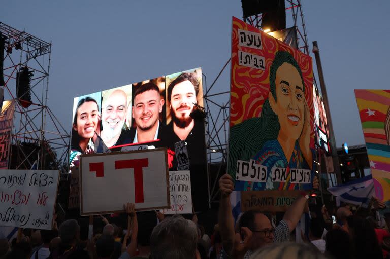 Noa Argamani, Shlomi Ziv, Almog Meir Jan y Andrey Kozlov, los cuatro rehenes israelíes rescatados por el ejército israelí, se levanta mientras activistas israelíes se concentran durante una manifestación contra el gobierno.