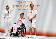 Tokyo 2020 Torch Relay Official Ambassadors, actress Satomi Ishihara, paralympian Aki Taguchi and judoist Tadahiro Nomura unveil the Olympic torchbeares' uniform during a Torch Relay event in Tokyo