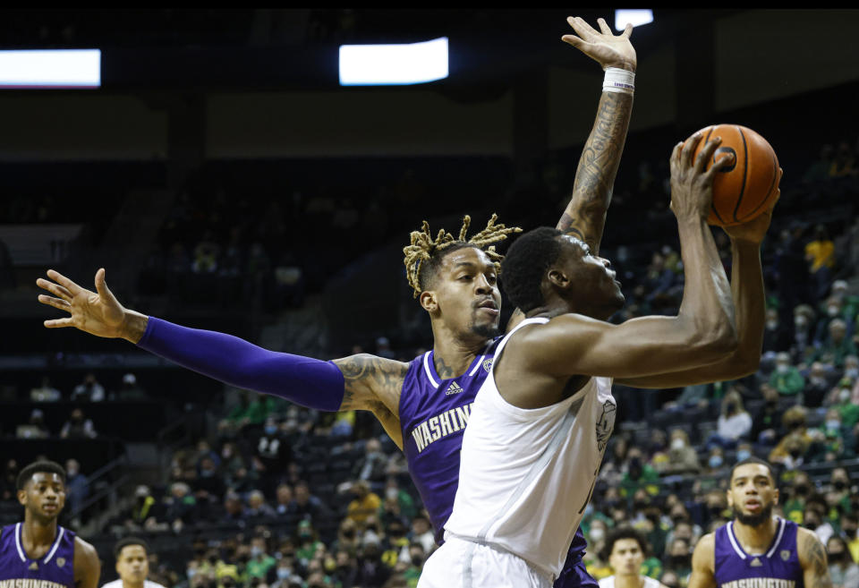 Oregon center N'Faly Dante shoots against Washington forward Nate Roberts in the first half of an NCAA college basketball game in Eugene, Ore., Sunday, Jan. 23, 2022. (AP Photo/Thomas Boyd)