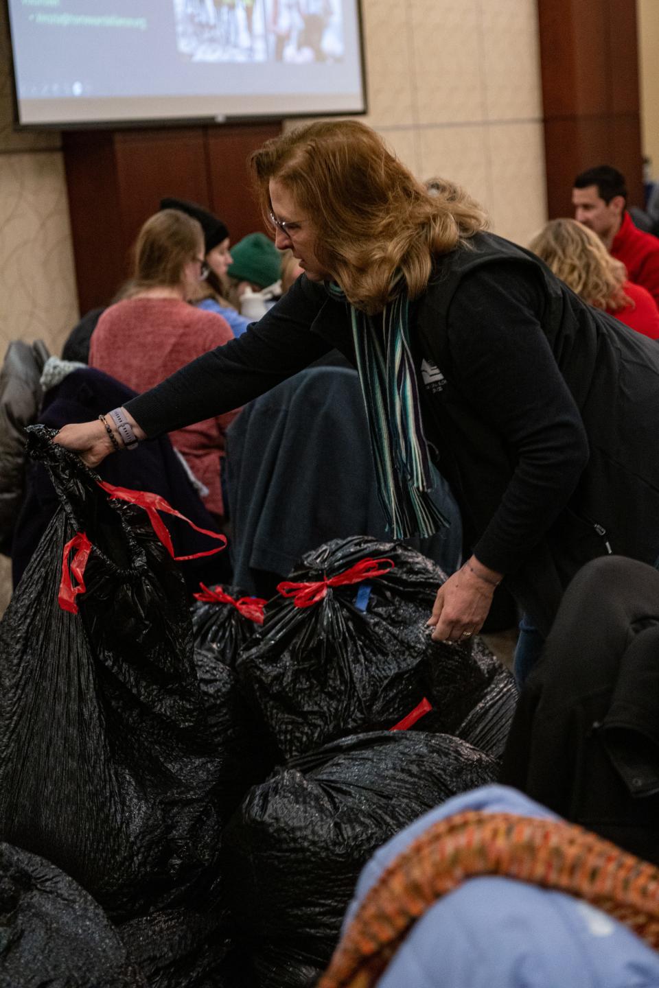 Larimer County Commissioner Jody Shadduck-McNally moves bags of organized donated clothes during the Martin Luther King Day 'Day of Service' volunteer event at the Lincoln Center in Fort Collins, Colo., on Monday, Jan. 15, 2024.