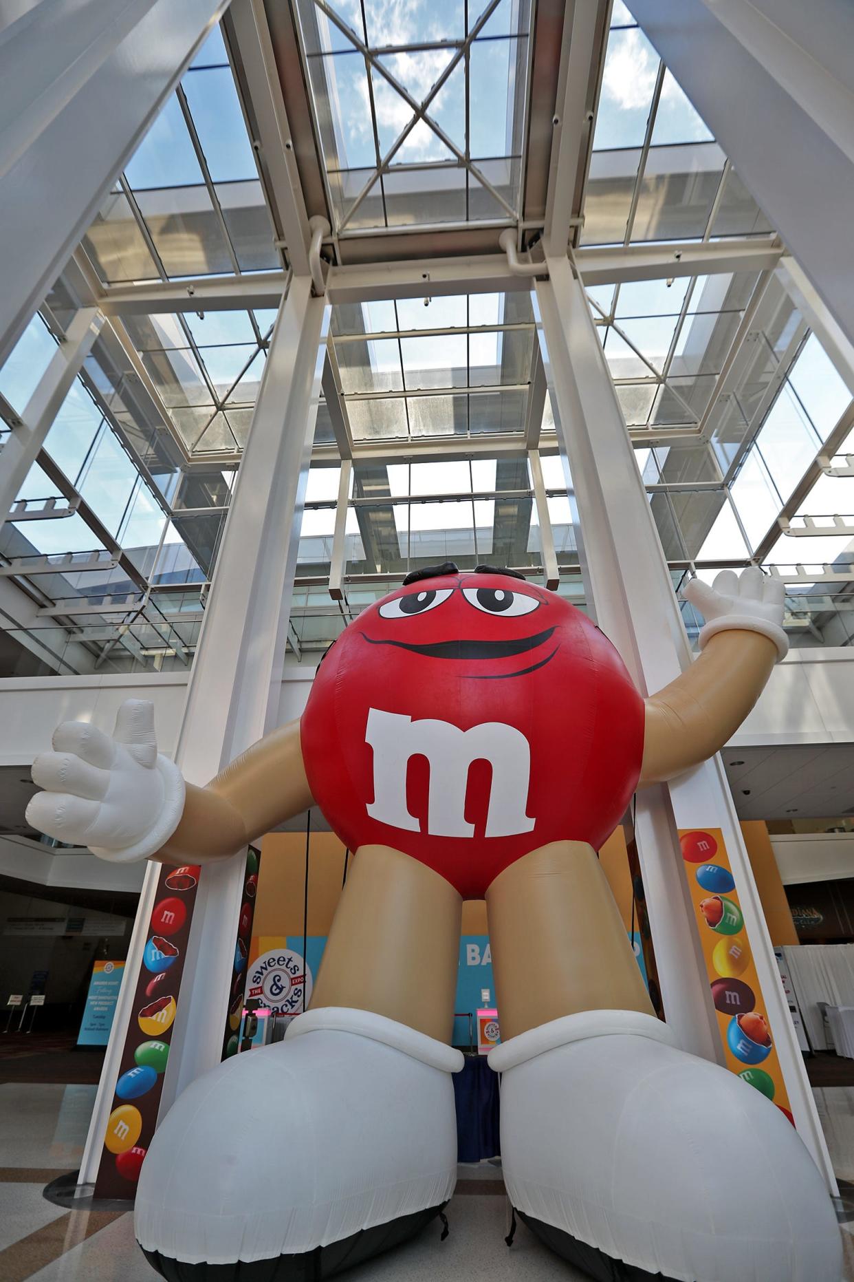 A giant inflated M&M waves to passersby from the Sweets & Snacks Expo, in a 2021 file photo.