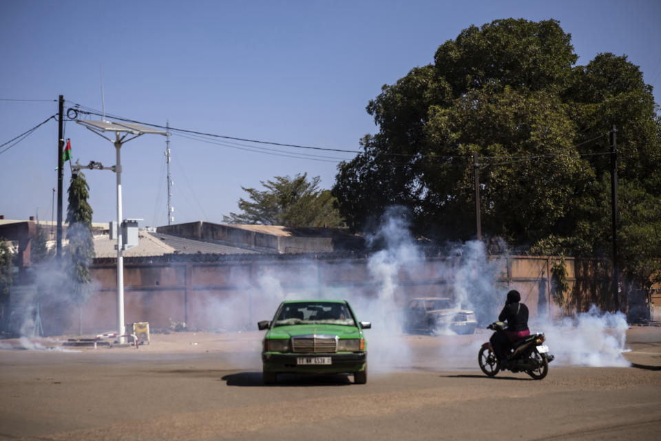 Tear gas is fired by the police to disperse the crowd gathered Place de la Nation in Burkina Faso's capital Ouagadougou Sunday Jan. 23, 2022. Witnesses are reporting heavy gunfire at a military base raising fears that a coup attempt is underway. Government spokesman Alkassoum Maiga acknowledged the gunfire but denied that the military had taken over the West African country. (AP Photo/Sophie Garcia)