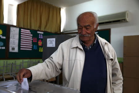 A Turkish Cypriot man casts his vote at a polling station in northern Nicosia April 26, 2015. REUTERS/Yiannis Kourtoglou