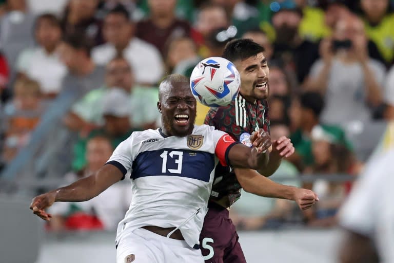 El ecuatoriano Enner Valencia lucha este domingo por una pelota con el mexicano Johan Vásquez. (Chris CODUTO)