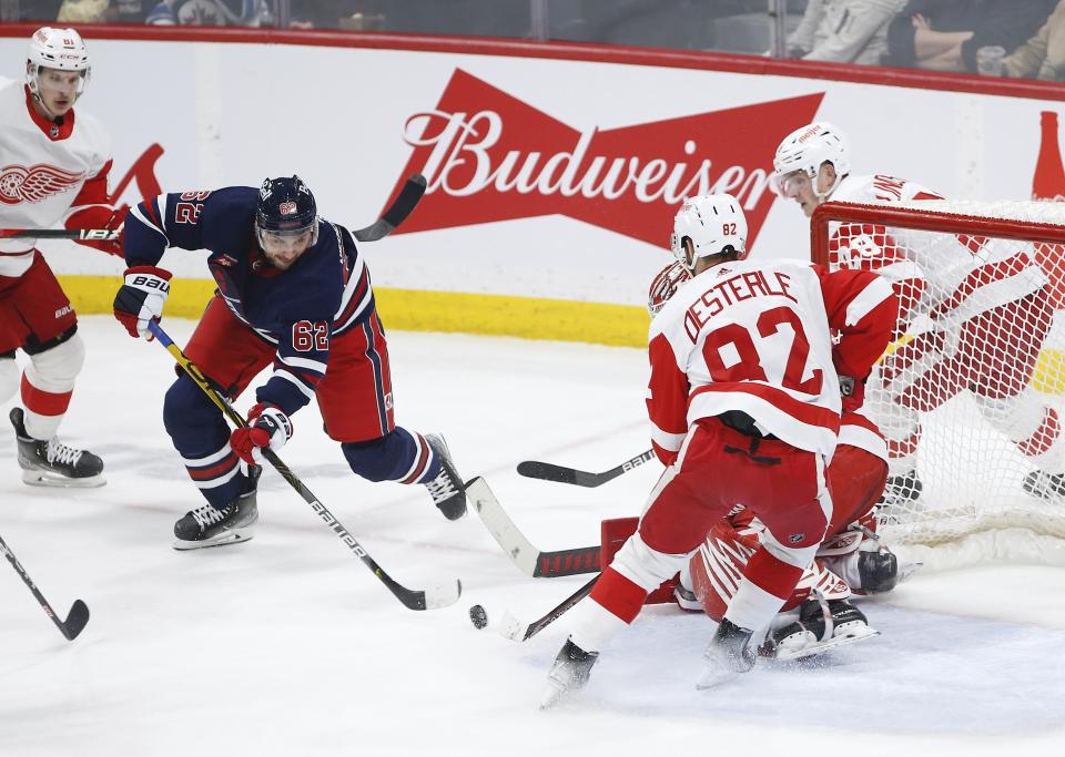 Winnipeg Jets' Nino Niederreiter (62) scores against Detroit Red Wings goaltender Magnus Hellberg (45) as Red Wings' Jordan Oesterle (82) defends during second-period NHL hockey game action in Winnipeg, Manitoba, Friday, March 31, 2023. (John Woods/The Canadian Press via AP)