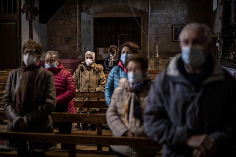 Parishioners stand while praying at the Saturday Mass the Catholic church of Cazurra, a village of around 75 inhabitants, in the Zamora province of Spain, Saturday, Nov. 27, 2021. Zamora has 304 parishes and only about 130 priests serving them. (AP Photo/Manu Brabo)