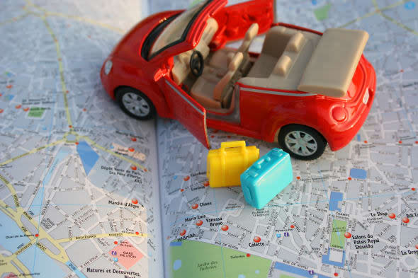 toy car on luggage on map of...