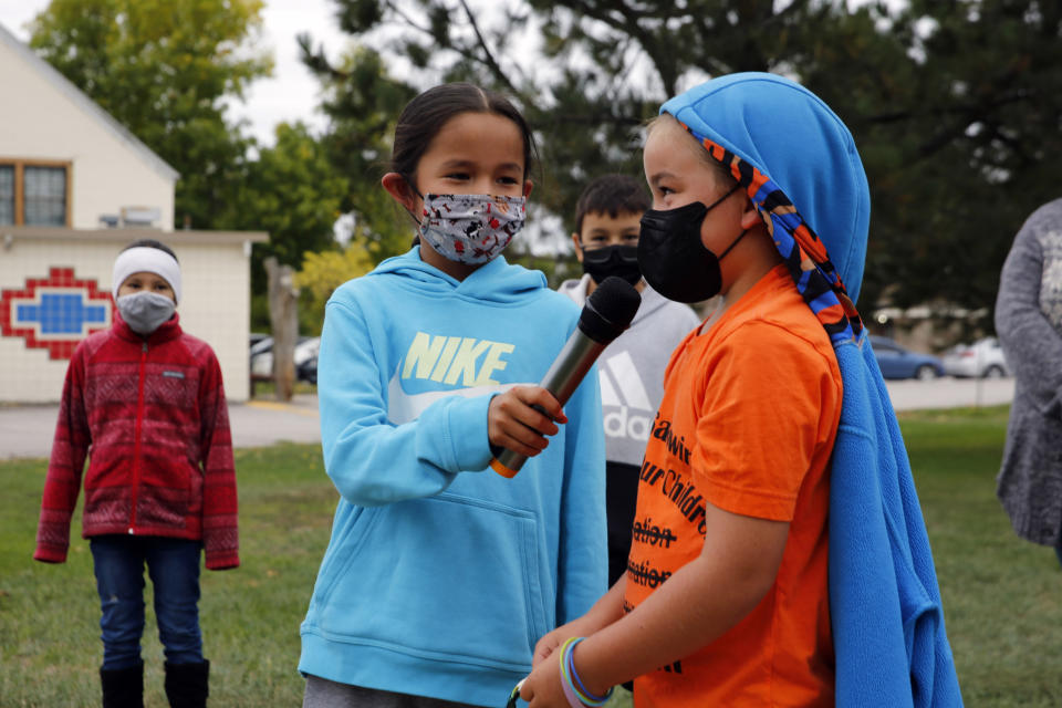 Elementary students at Red Cloud Indian School sing at an assembly for Orange Shirt Day on Sept. 30, 2021, in Pine Ridge, S.D. Students and teachers wore orange in solidarity with Indigenous children of past generations who suffered cultural loss, family separation and sometimes abuse and neglect while compelled to attend hundreds of residential schools that once dotted the map across the United States and Canada from the late 19th to the mid-20th centuries. (AP Photo/Emily Leshner) (AP Photo/Emily Leshner)