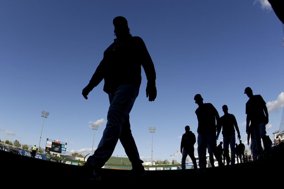 Cleveland Indians players walk to the clubhouse after beating the Kansas City Royals 9-5 in a spring training baseball game Sunday, Feb. 23, 2020, in Surprise, Ariz. (AP Photo/Charlie Riedel)