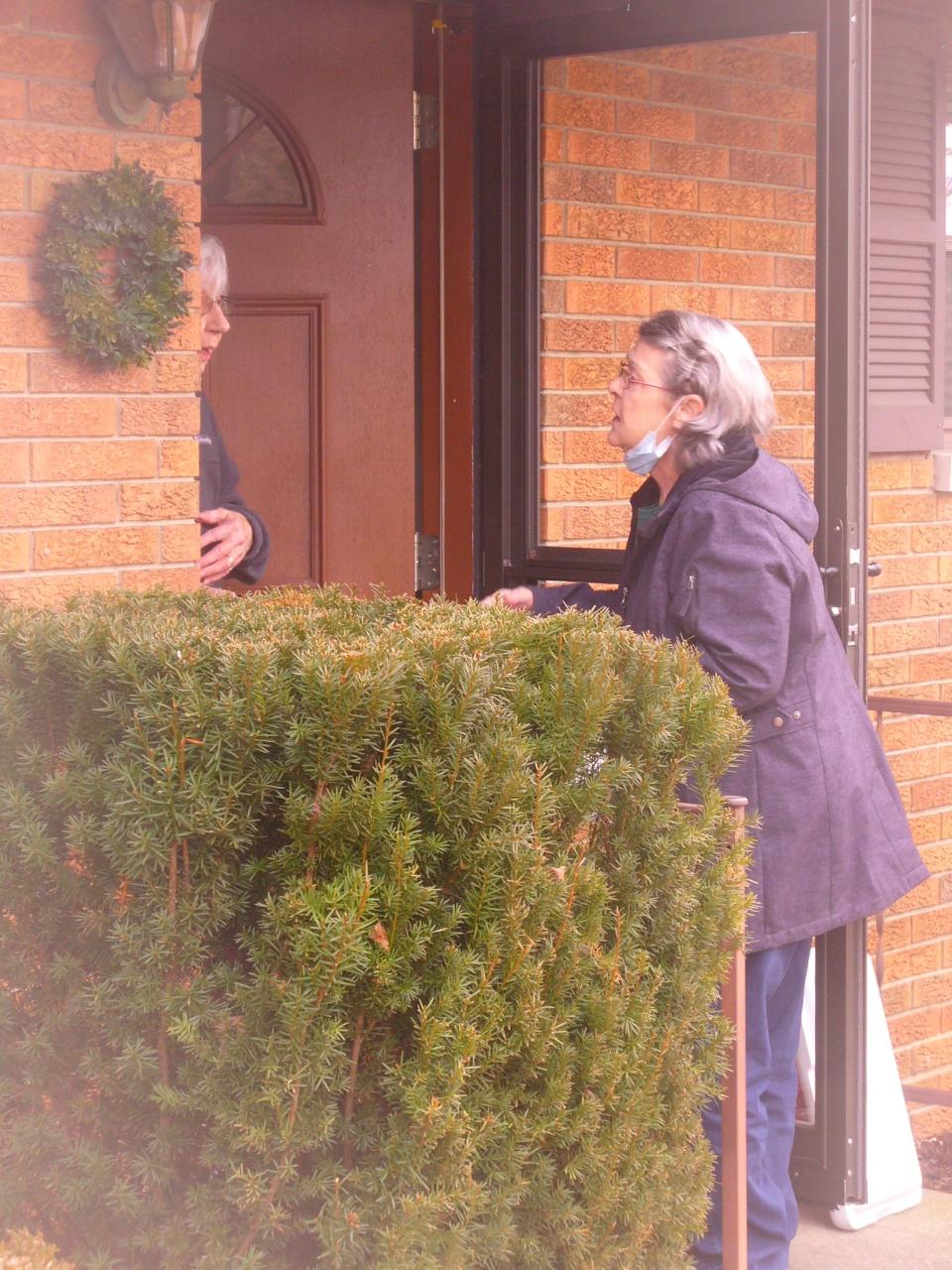 Pat Winter speaks to a client while making the midday delivery along a Meals on Wheels route on the south side of Bloomington.