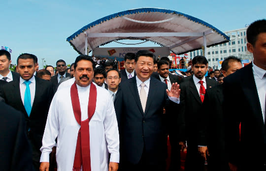 習近平2014年前往斯里蘭卡可倫坡港，和斯里蘭卡時任總統拉賈帕克薩出席人工島建造開工典禮。美聯社