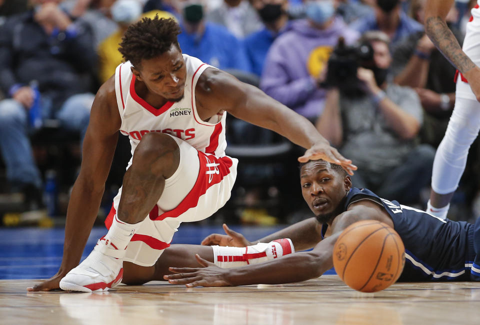 Houston Rockets forward Jae'Sean Tate, left, and Dallas Mavericks forward Dorian Finney-Smith, right, vie for a loose ball during the second half of an NBA basketball game, Tuesday, Oct. 26, 2021, in Dallas. Dallas won 116-106. (AP Photo/Brandon Wade)