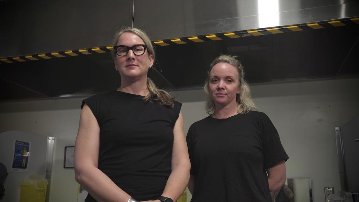 Wendy Stewart, left, director of Sandy Hill Community Health Centre's OASIS program, and Amanda Gunn, right, consumption and treatment services team lead, stand in front of the centre's new vent hoods that are intended to suck out harmful fumes. (Nick Persaud/CBC - image credit)