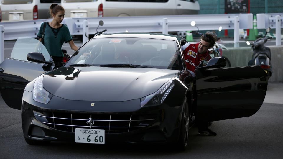 Ferrari Formula One driver Fernando Alonso of Spain and his girlfriend Dasha Kapustina leave after the qualifying session of the Japanese F1 Grand Prix at the Suzuka circuit October 12, 2013. REUTERS/Toru Hanai (JAPAN - Tags: SPORT MOTORSPORT F1 ENTERTAINMENT)