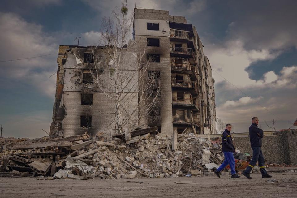 Firefighters walk by the destroyed remains of Borodyanka (Bel Trew)